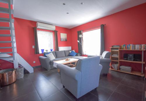 a living room with red walls and a couch and chairs at land s' end in Philippine