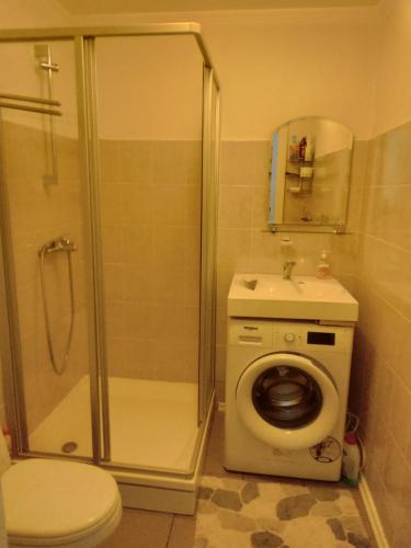 uma casa de banho com um chuveiro, um WC e um lavatório. em Siguldas Street Apartment in Ventspils em Ventspils