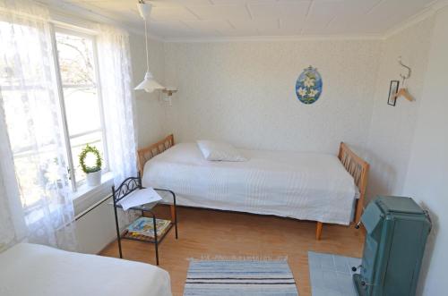 una piccola camera con due letti e una finestra di Dunderås Stugan a Skillingaryd