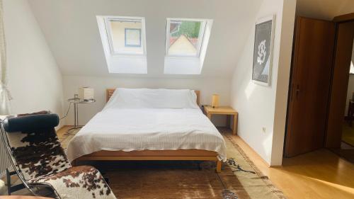 a bedroom with a bed and a window and a chair at Schlossapartments Wolfsberg in Wolfsberg