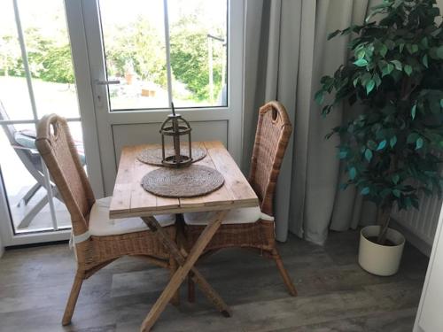 a wooden table with two chairs and a lamp on it at Luxe prive-kamer - studio in villa aan zee, Dishoek, vernieuwd in Dishoek