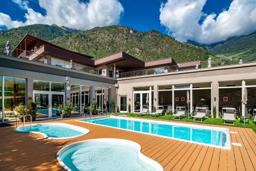 an exterior view of a house with a swimming pool at Vitalpina Hotel Waldhof in Rablà
