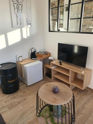 a living room with a table and a television at Instant secret in Pourrières