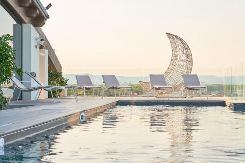 a row of chairs sitting next to a swimming pool at Palace Lido Hotel & Suites in Marina di Cecina