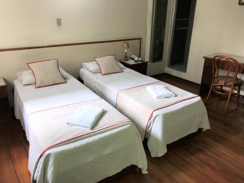 duas camas num quarto de hotel com lençóis brancos em Hotel São Jorge São Paulo - By UP Hotel - próximo a 25 de março, fácil acesso ao Expo Center Norte e Mercado Municipal SP em São Paulo