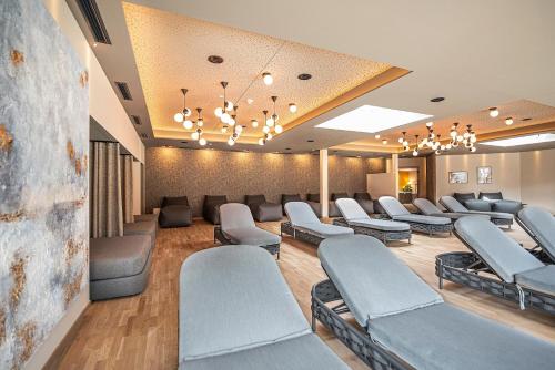 a waiting room with couches and chairs at Vitalpina Hotel Waldhof in Rablà