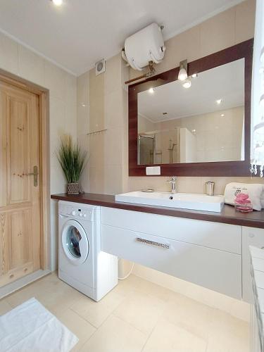 a bathroom with a sink and a washing machine at Olczański Dom in Zakopane