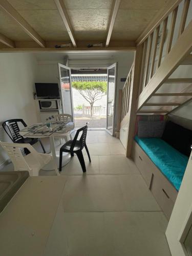 une petite chambre avec une table et des chaises ainsi qu'une salle à manger dans l'établissement Maisonnette climatisée dans résidence naturiste, à Leucate