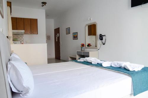 a bedroom with a large white bed with towels on it at Aliki Studios in Parga