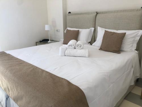 a large white bed with two towels on it at Relais Masseria Villa Cenci in Cisternino