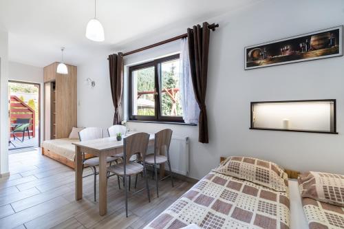 1 dormitorio con 2 camas, mesa y sillas en U Francuza, en Międzybrodzie Żywieckie