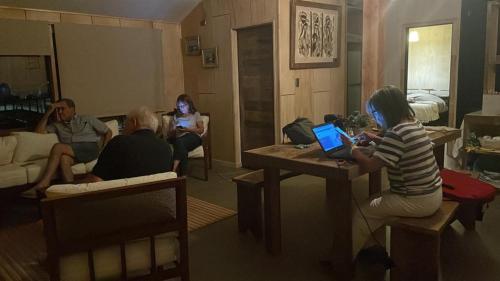 a group of people sitting in a living room with a laptop at CASA VISTA CORRAL in Malalcahuello