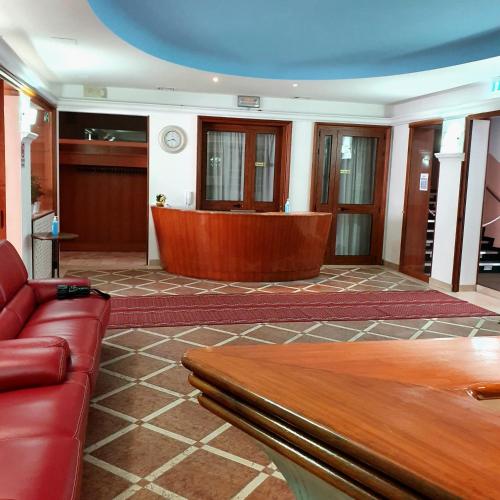 a living room with a couch and a desk at HOTEL PERLA in Massa Lombarda