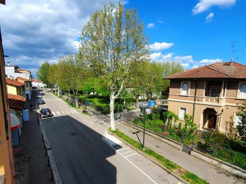 a view of a street with a tree and houses at HOTEL PERLA in Massa Lombarda