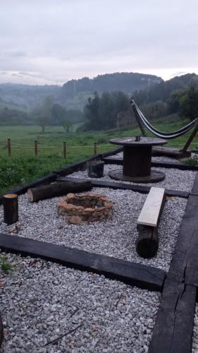 a fire pit with logs on a gravel field at Glamping Quintana in Gijón