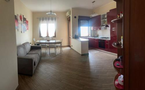 sala de estar y cocina con sofá y mesa en Casa vacanze Home To Go, en Caulonia Marina