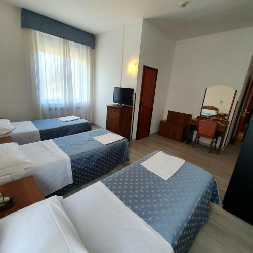a hotel room with two beds and a television at HOTEL PERLA in Massa Lombarda