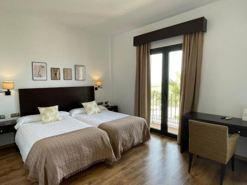 a bedroom with a large bed and a large window at Hacienda Atalaya in La Rambla