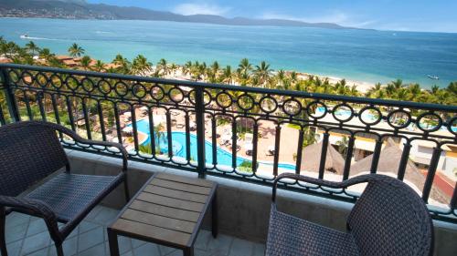 a balcony with two chairs and a view of the beach at Fiesta Americana Puerto Vallarta All Inclusive & Spa in Puerto Vallarta