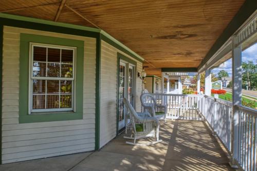 a porch of a house with two chairs on it at Carlisle Inn Walnut Creek in Walnut Creek
