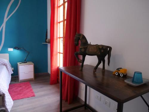 um cavalo de brinquedo em cima de uma mesa numa sala em B&B Des Artistes em Borzano