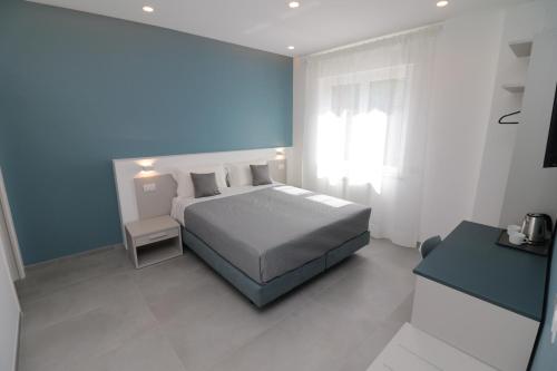 sypialnia z łóżkiem i niebieską ścianą w obiekcie Maison Nanà w Sorrento