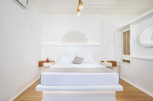 a white bedroom with a large white bed in it at Agnadi studios in Maltezana