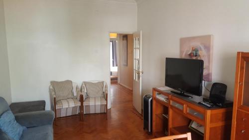 a living room with a tv and a couch and chairs at Almirante 48 Two Bedroom in Lisbon