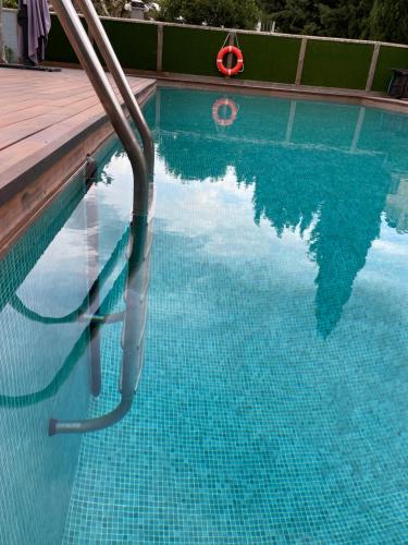a swimming pool with a reflection of the sky in the water at Julia’s Garden in Cuarte de Huerva