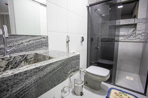 uma casa de banho com um lavatório, um WC e um chuveiro em Paulo Hotel e Restaurante em Patos de Minas