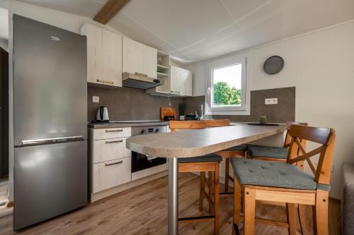 a kitchen with a stainless steel refrigerator and a table at Mobile House Bojnice in Bojnice