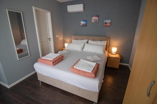 1 dormitorio con 1 cama con 2 almohadas y espejo en Villa M en Mostar