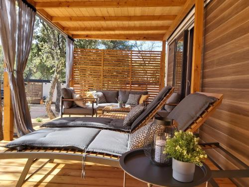 un porche cubierto con cama y mesa en Mobile Home Sole, en Biograd na Moru