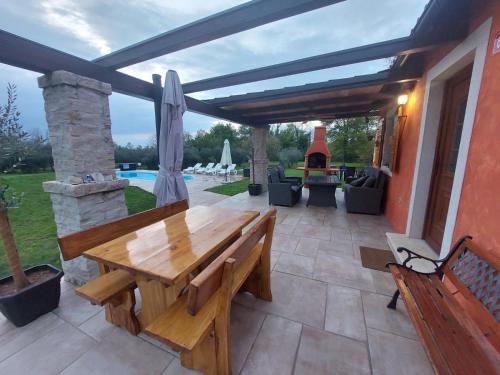 a patio with a wooden bench and a table at House in nature in Tinjan