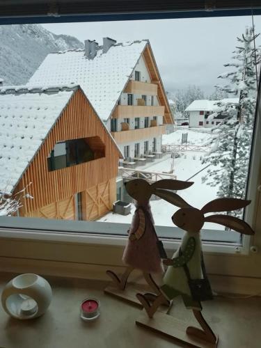 two stuffed animals standing in front of a window at Apartma Marjetica in Gozd Martuljek