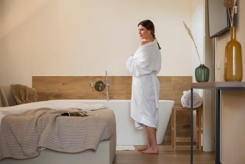 Una mujer parada en una bañera en una habitación en Botrona B&B, en Scarlino