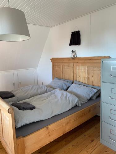 a bed in a room with a wooden bed frame at Selvbetjent lejlighed i centrum ved åen in Ribe