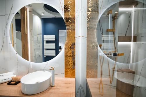 łazienka z białą umywalką i lustrem w obiekcie Boutique 62 by Housine w Zatorze