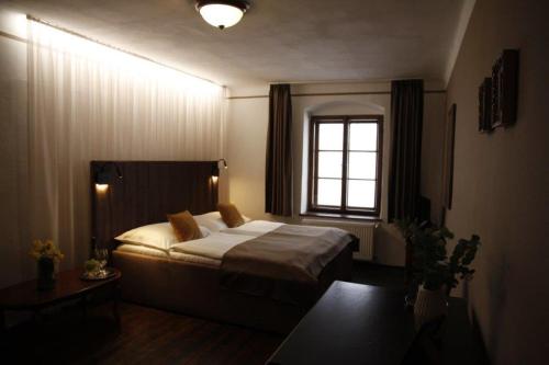 a bedroom with a bed and a window at Hotel Svambersky dum in Český Krumlov