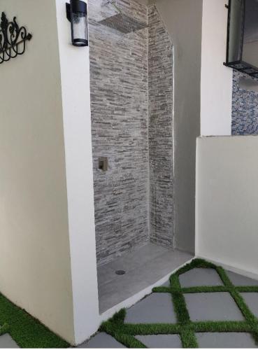 a shower in a room with a brick wall at Blue Royalty in Portmore