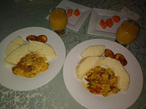 two plates of food and two glasses of orange juice at Blue Royalty in Portmore