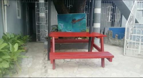 a red bench sitting in front of a building at Blue Royalty in Portmore