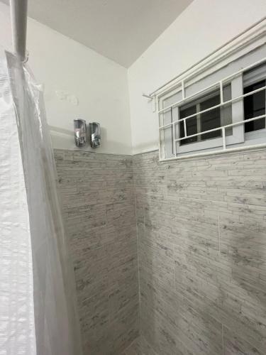 a bathroom with a shower and a window at Blue Royalty in Portmore