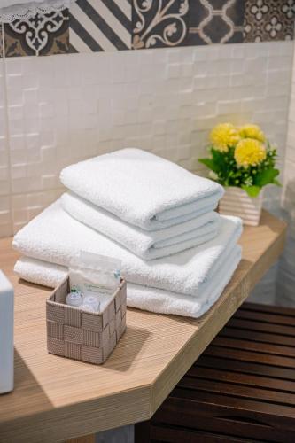 a stack of towels on a table with a pile of towels at BellaVista in Taormina