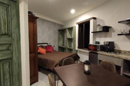 Habitación con cama, mesa y cocina. en La solitudine di Anquiato, en Santeagueda