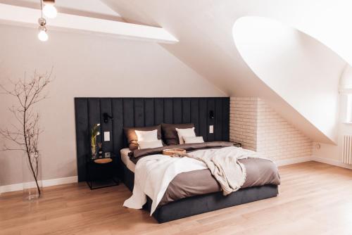 a bedroom with a large bed with a black headboard at Orbis in Pisz