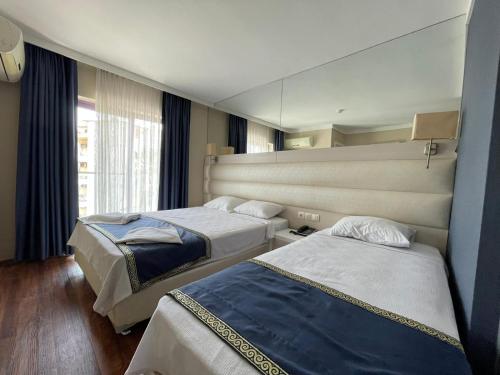 a hotel room with two beds and a mirror at Gold Butik Otel in Marmaris