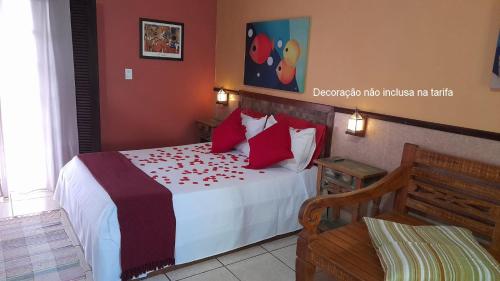 a bedroom with a bed with red pillows at Chalés Terras Altas de Paraty in Paraty