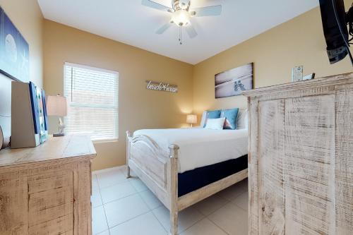 1 dormitorio con 1 cama y ventilador de techo en Kingfisher en South Padre Island