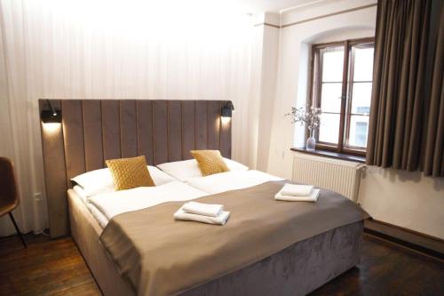a bedroom with a large bed with two towels on it at Hotel Svambersky dum in Český Krumlov